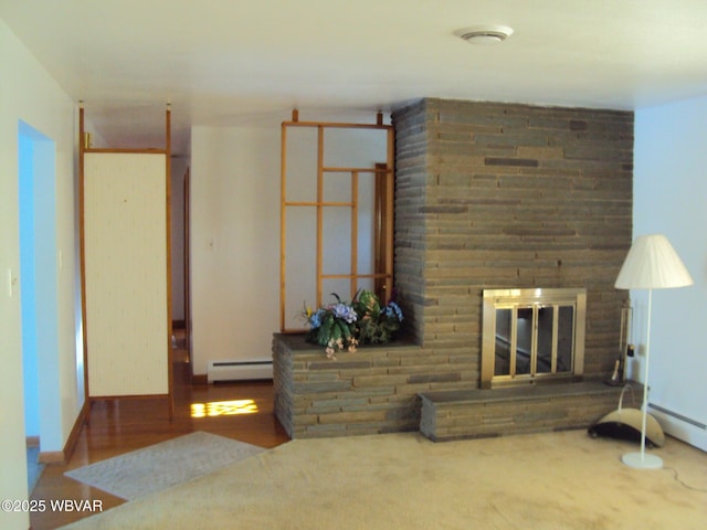 unfurnished living room with a large fireplace and baseboard heating