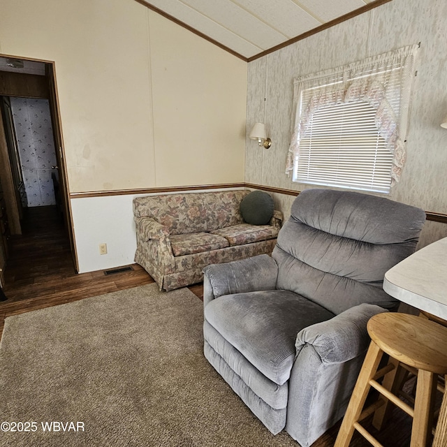 living area featuring ornamental molding, vaulted ceiling, and wood finished floors