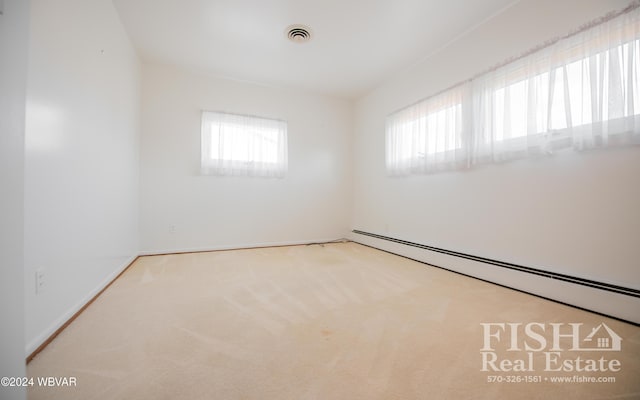 empty room with baseboard heating, carpet flooring, and plenty of natural light