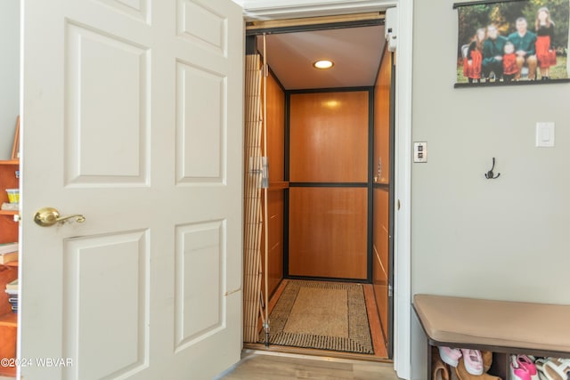 details with elevator and wood-type flooring