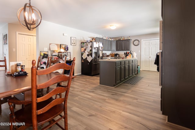 dining space with light hardwood / wood-style flooring and a chandelier