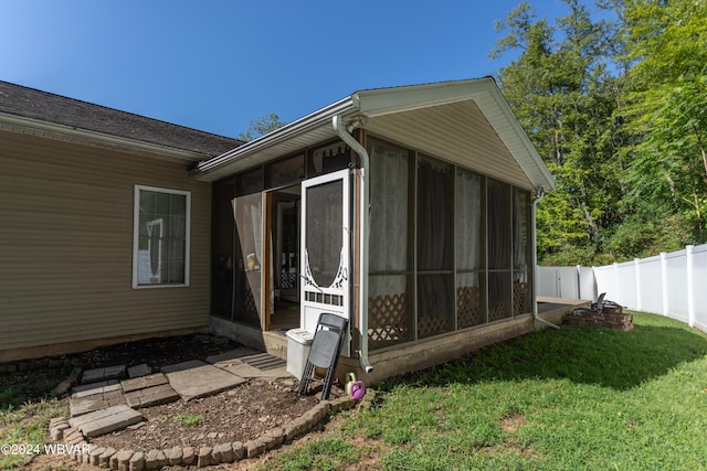 view of side of property featuring a sunroom and a lawn