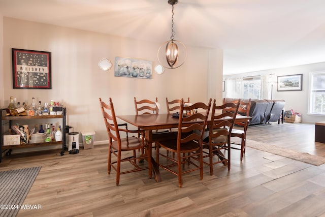 dining room with light wood-type flooring and an inviting chandelier