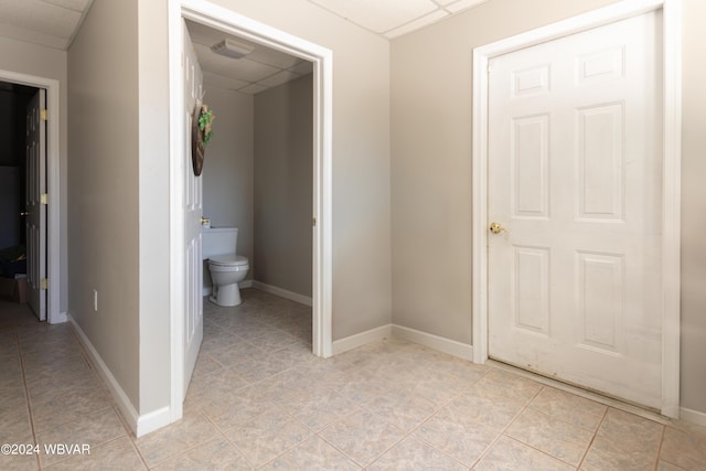 bathroom featuring tile patterned floors, a paneled ceiling, and toilet