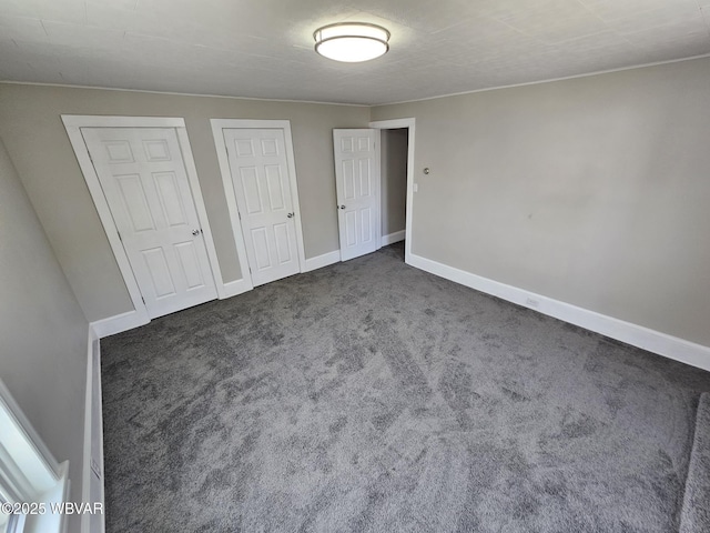 unfurnished bedroom featuring carpet floors and baseboards