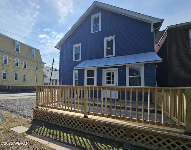 back of house with a wooden deck, metal roof, and a standing seam roof