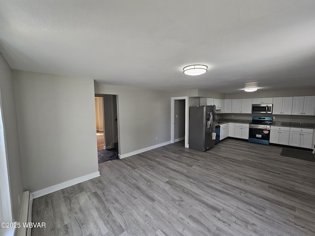 kitchen with appliances with stainless steel finishes, baseboards, dark wood-style flooring, and white cabinetry