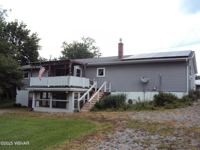 117 Oak Ln, Lock Haven, PA 17745 - rear view of house featuring a chimney, roof mounted solar panels, stairway, and a lawn