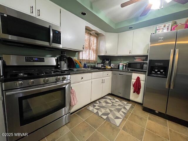 kitchen with light tile patterned flooring, white cabinetry, ceiling fan, and stainless steel appliances