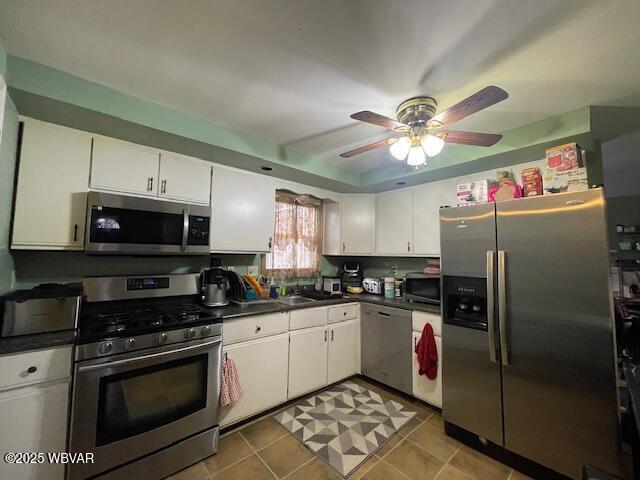 kitchen featuring ceiling fan, white cabinets, light tile patterned floors, and appliances with stainless steel finishes