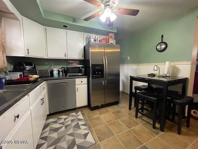 kitchen with stainless steel appliances, white cabinetry, ceiling fan, and sink