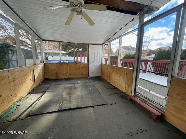 unfurnished sunroom featuring ceiling fan and lofted ceiling