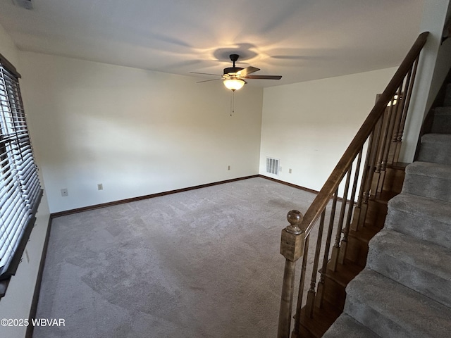 carpeted spare room with ceiling fan