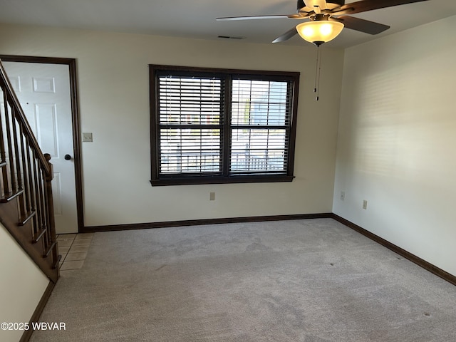 carpeted spare room with ceiling fan