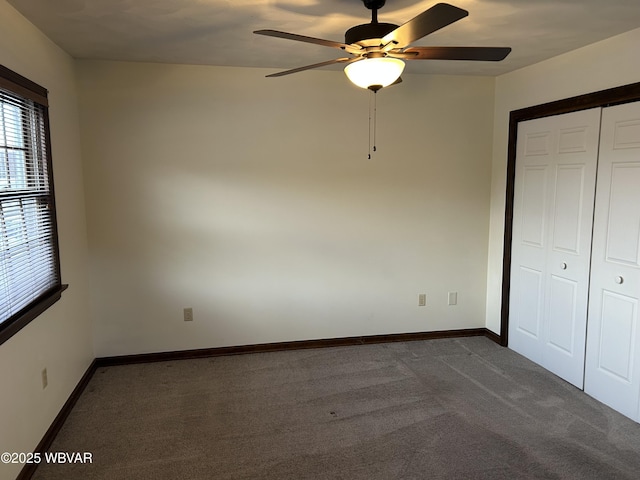 unfurnished bedroom featuring a closet, ceiling fan, and dark colored carpet