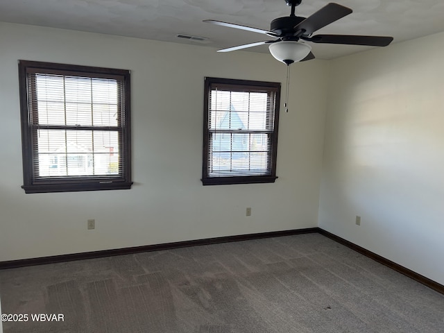 unfurnished room with ceiling fan, plenty of natural light, and dark carpet