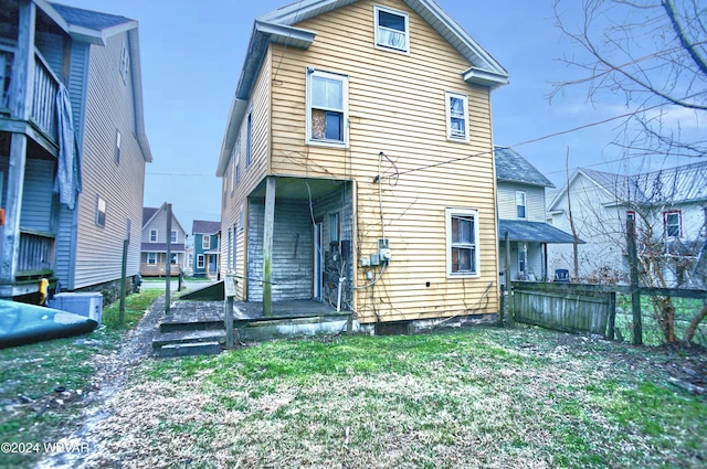 rear view of property featuring a lawn