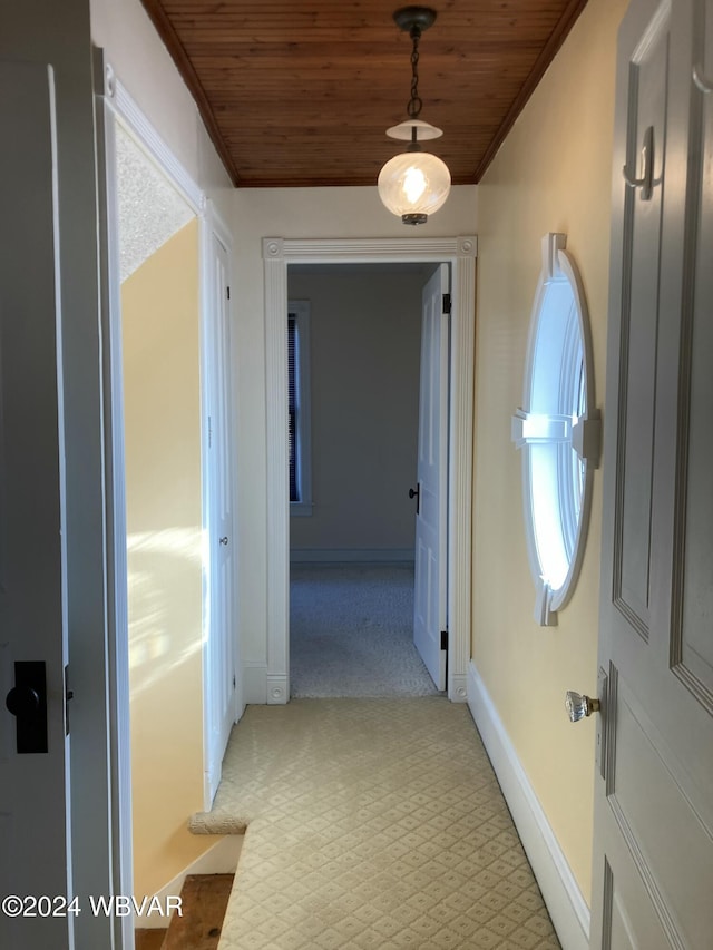 corridor featuring ornamental molding, light colored carpet, and wooden ceiling