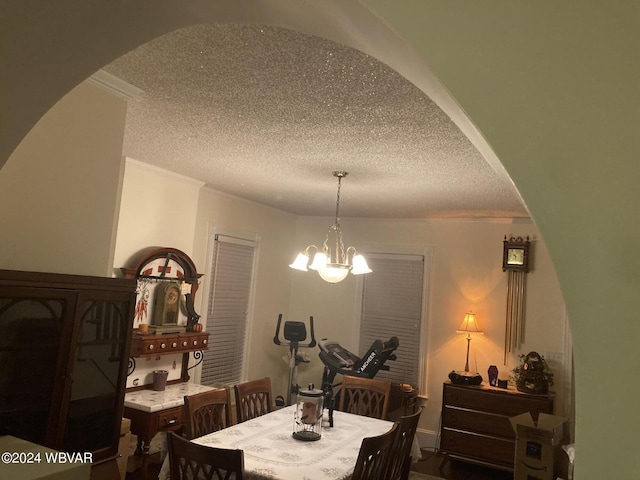 dining area featuring a textured ceiling, an inviting chandelier, and ornamental molding