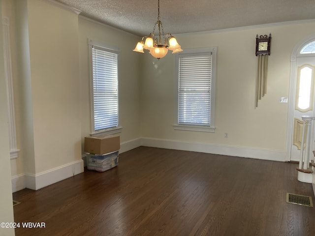 interior space with a textured ceiling, dark hardwood / wood-style flooring, an inviting chandelier, and crown molding