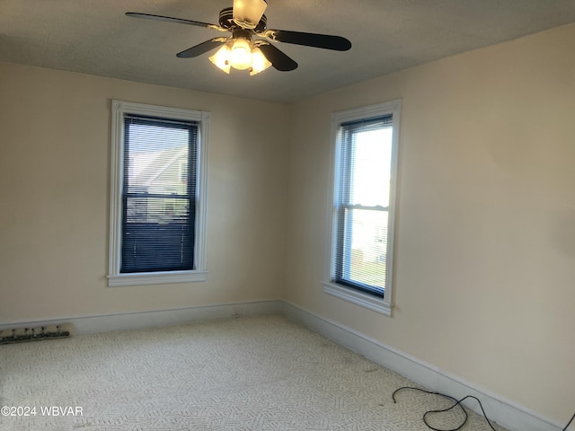 carpeted spare room featuring ceiling fan