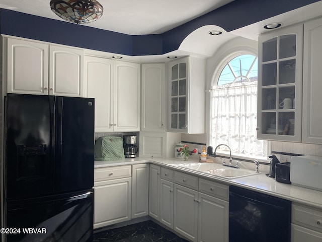 kitchen featuring sink, tasteful backsplash, white cabinetry, and black appliances