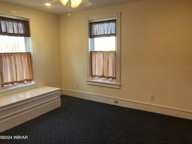 unfurnished room featuring carpet, ceiling fan, and a wealth of natural light