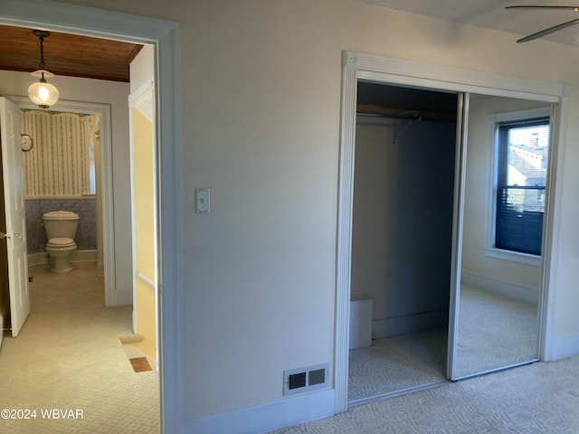 unfurnished bedroom with connected bathroom, a closet, and light colored carpet