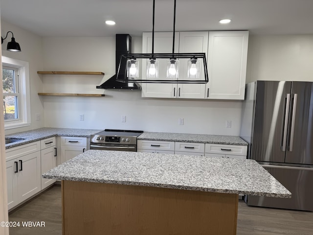 kitchen featuring appliances with stainless steel finishes, ventilation hood, decorative light fixtures, white cabinets, and dark hardwood / wood-style floors