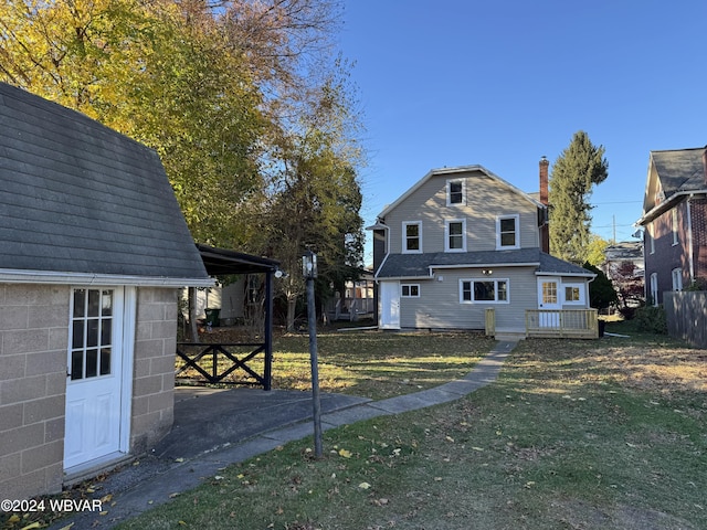 rear view of house with a lawn and a wooden deck