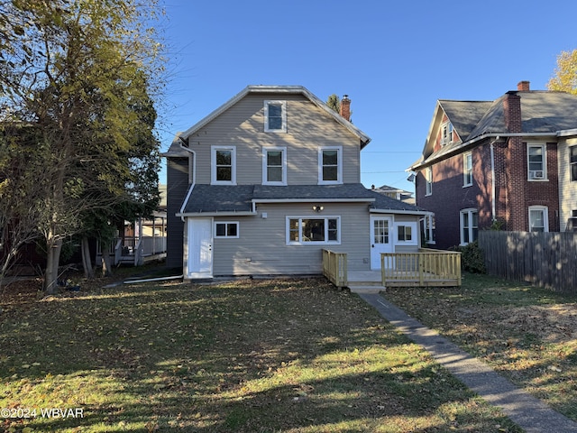 back of house with a wooden deck and a lawn