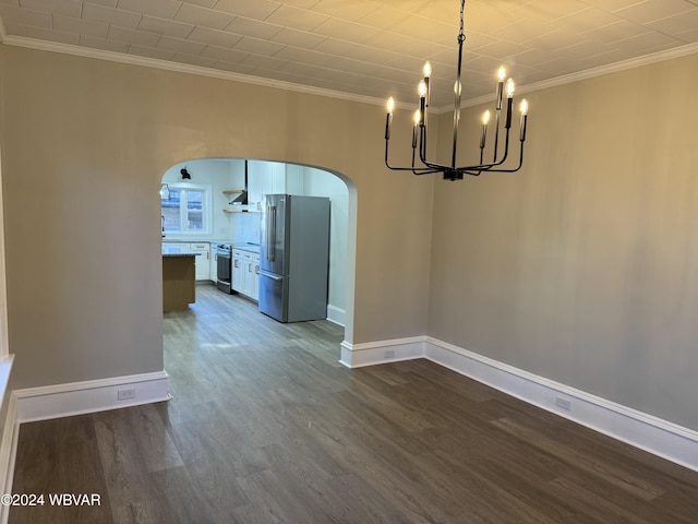 unfurnished dining area with hardwood / wood-style floors, ornamental molding, and a chandelier