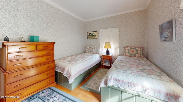 bedroom with ornamental molding, light wood-style floors, and wallpapered walls