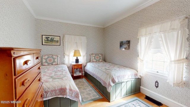 bedroom featuring ornamental molding, multiple windows, baseboards, and wallpapered walls