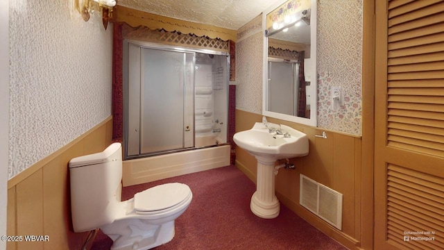 full bathroom featuring toilet, wainscoting, visible vents, and wallpapered walls