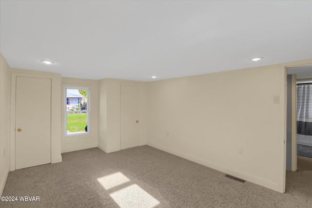 unfurnished room featuring light carpet