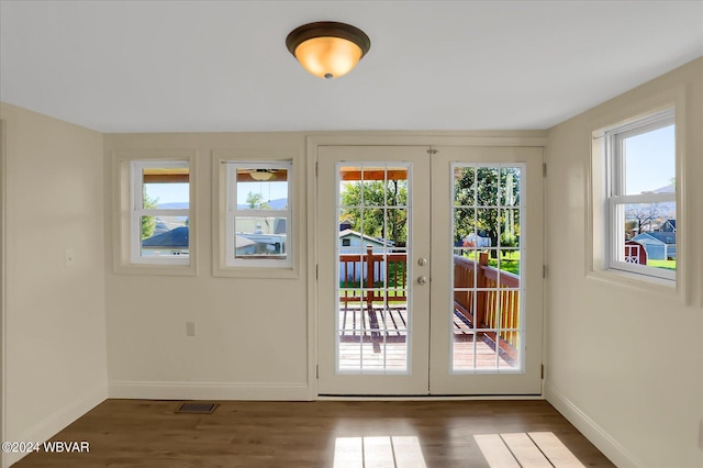 doorway to outside with french doors, plenty of natural light, and dark wood-type flooring