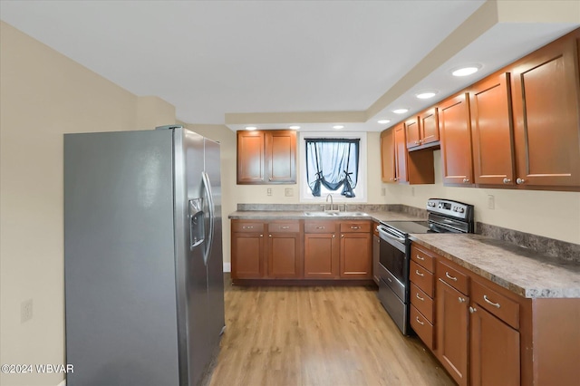 kitchen with light wood-type flooring, stainless steel appliances, and sink