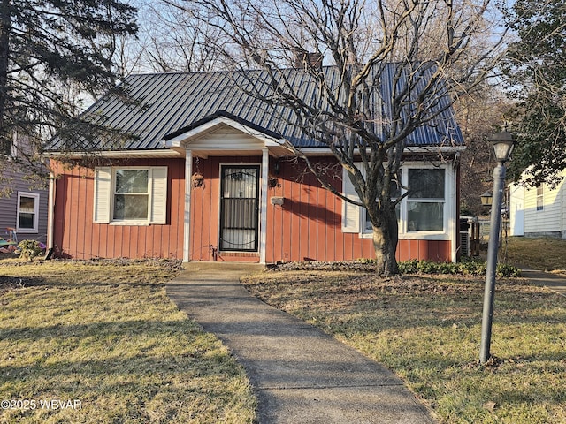 bungalow-style home featuring a standing seam roof, board and batten siding, metal roof, and a front yard