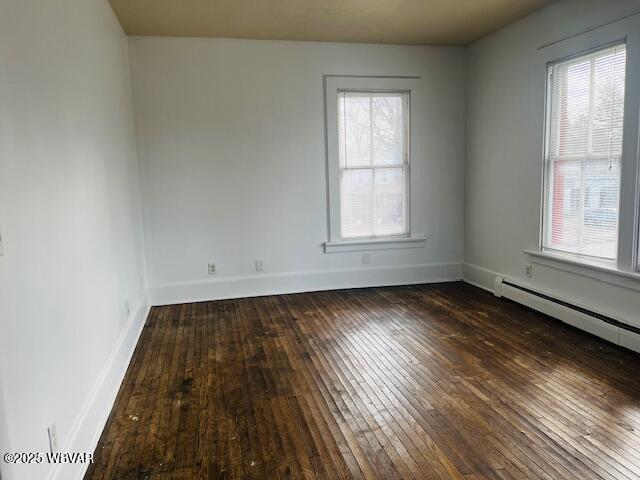 unfurnished room featuring dark wood-style flooring and baseboards