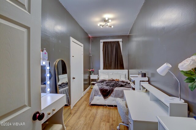 bedroom featuring a chandelier and light hardwood / wood-style flooring