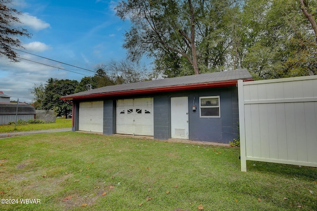 view of outbuilding featuring a lawn and a garage