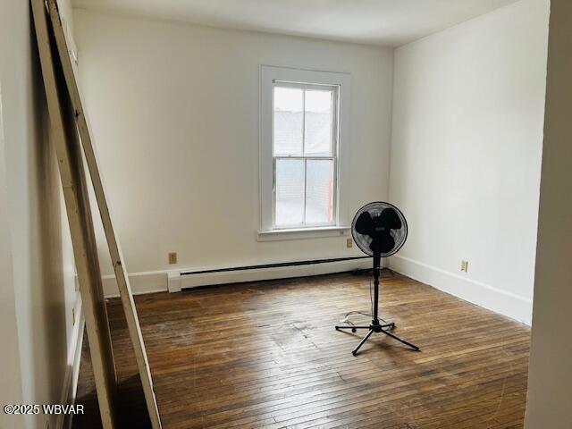 interior space featuring baseboard heating and dark hardwood / wood-style floors