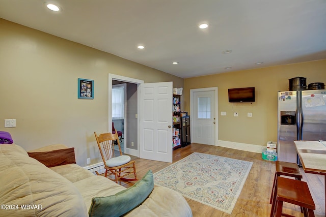 living room with baseboards, a baseboard radiator, wood finished floors, and recessed lighting