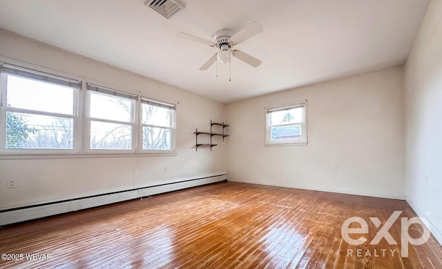 empty room with a baseboard heating unit, visible vents, baseboards, a ceiling fan, and hardwood / wood-style floors