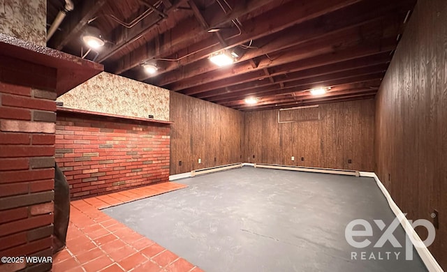 finished below grade area featuring wood walls and baseboard heating