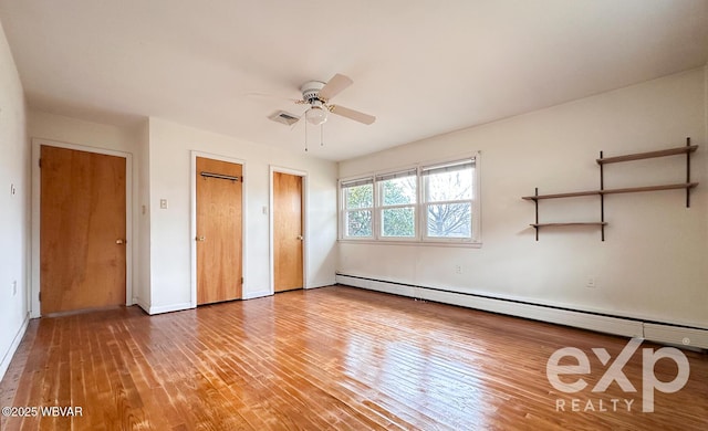 unfurnished bedroom featuring a baseboard heating unit, light wood-type flooring, visible vents, and a ceiling fan