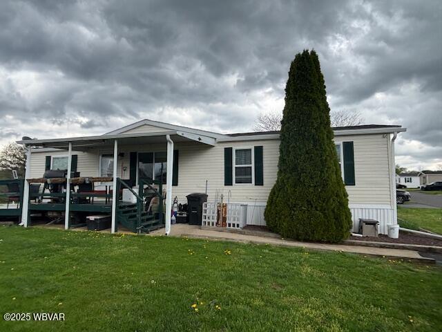 rear view of property featuring a lawn
