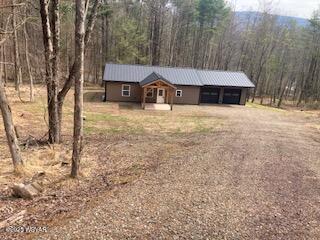 131 Spring House Rd, Muncy Valley, PA 17758 - view of front of house featuring a carport, dirt driveway, a forest view, and metal roof