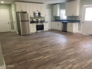 131 Spring House Rd, Muncy Valley, PA 17758 - kitchen featuring dark countertops, dark wood-style flooring, baseboards, appliances with stainless steel finishes, and white cabinetry